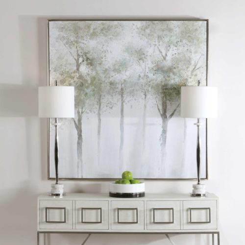 serene artwork pieces above a console table with lamps.