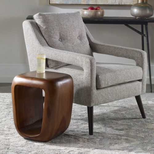 Brown accent table stool next to grey accent chair 